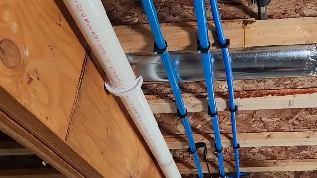 Blue PEX supply lines and a white PVC drain pipe clipped to basement joists above insulated ductwork