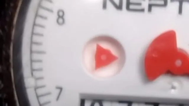 Close view of a Neptune water meter face with a low-flow triangle indicator and red markers