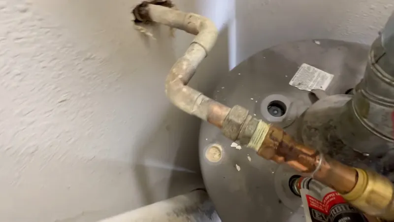 Copper supply pipe and flexible connector joined to the top fittings of a gray water heater tank