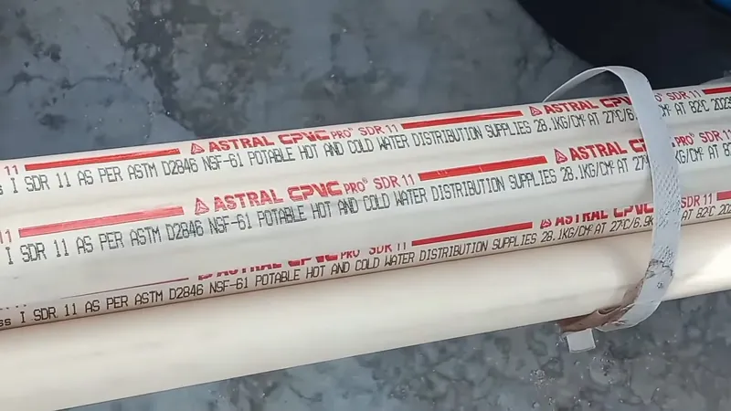 Length of white CPVC water supply pipe with printed SDR 11 rating text and a metal strap